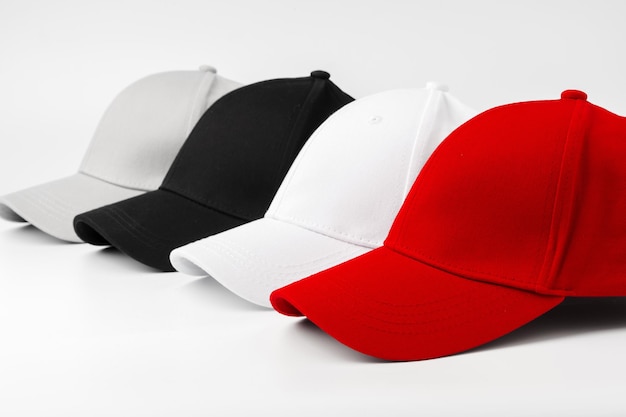 Lineup de quatro bonés de beisebol em branco vermelho e preto em um fundo branco