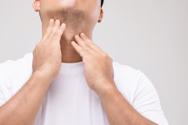 Linfoma en concepto de hombres: Retrato de hombre asiático está tocando su cuello en la posición de los ganglios linfáticos.