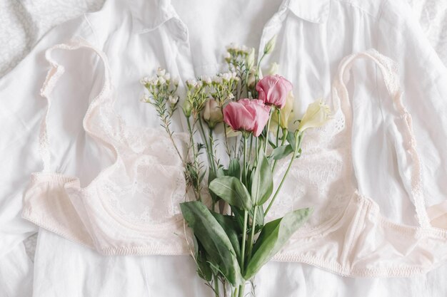 Lingerie de renda elegante e flores de primavera na camisa na cama Imagem suave e moderna Fragrância para o dia da mulher