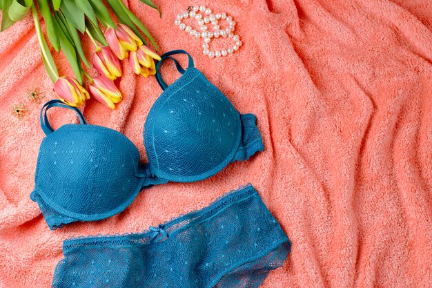 Foto lingerie de renda na cama com flores e jóias