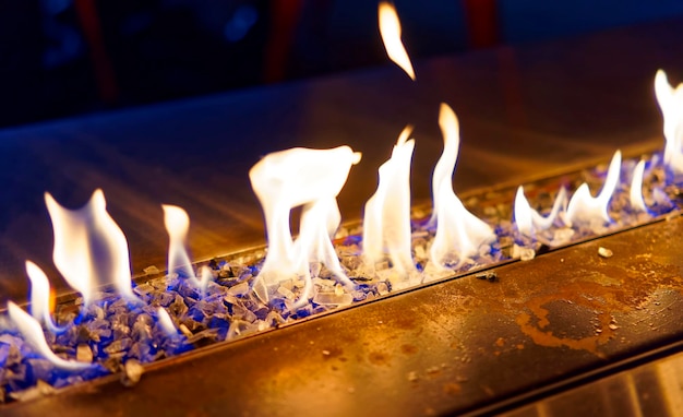 Foto língua azul de chamas de fogo queimando na lareira nas instalações escuras no final da noite
