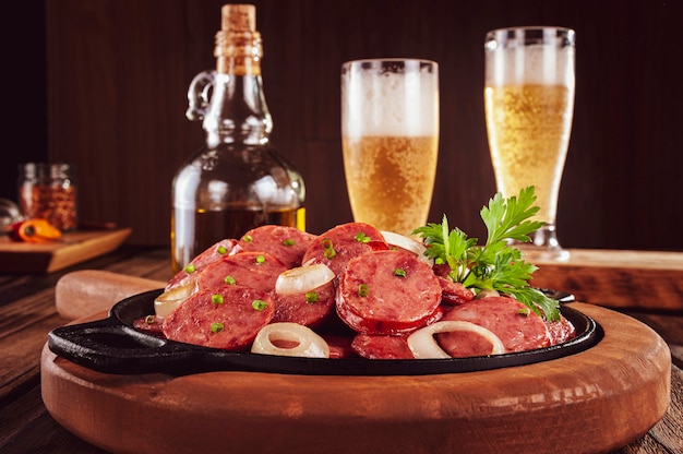 Foto linguiça calabresa defumada fatiada com cebola e cerveja - petisco brasileiro