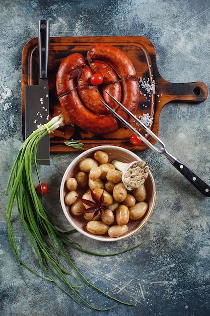 Foto linguiça caseira grelhada com batata jovem e cebolinha