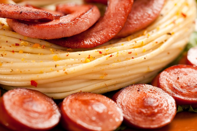 Linguiça grelhada com macarrão, verduras e temperos