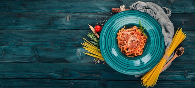 Linguine Pasta mit Tomaten auf einem hölzernen Hintergrund Italienische Küche Draufsicht Kopieren Sie Platz
