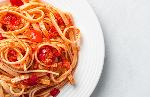 Linguini-Nudeln mit Tomatensauce auf grauem Hintergrund