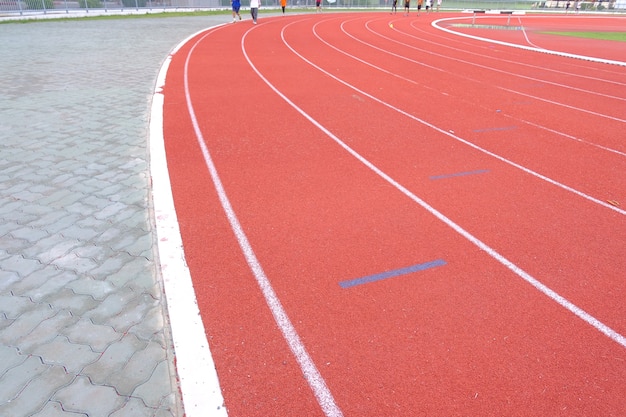 Linha branca da trilha no estádio vermelho do assoalho para funcionar e movimentar-se.