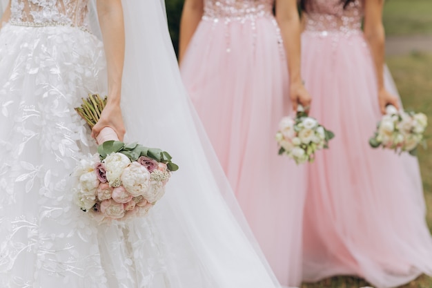 Linha de damas de honra com buquês na cerimônia de casamento