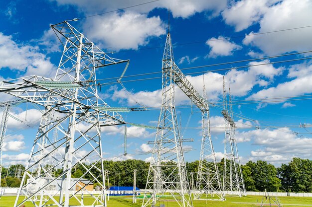 Linha de energia no campo contra um céu azul e hera verde Conceito de tecnologias de visão inferior