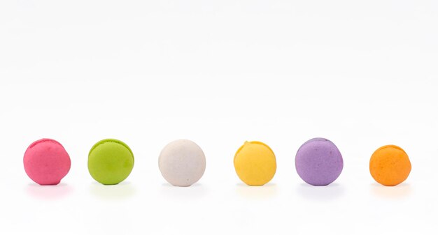 Linha de mini macarons coloridos de vários sabores no fundo branco