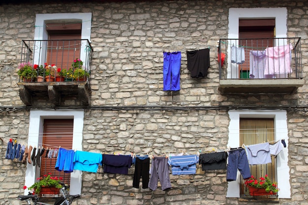 Linha de roupa pendurada em casas de parede de pedra