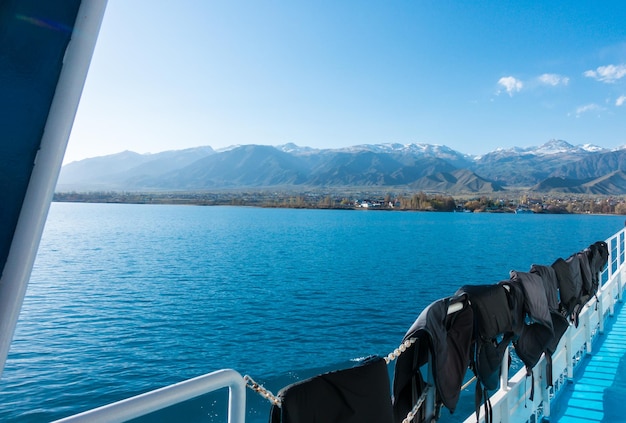 Linha de vida de popa do navio Pegada na água do barco Água azul e montanhas no horizonte IssykKul Quirguistão