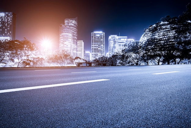 Linha do horizonte do pavimento da via expressa e cenário noturno da paisagem arquitetônica moderna