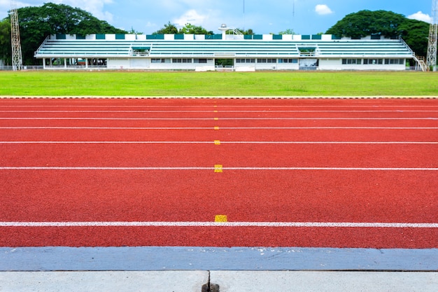 Linhas brancas de estádio e textura de pistas de borracha vermelhas da pista running.