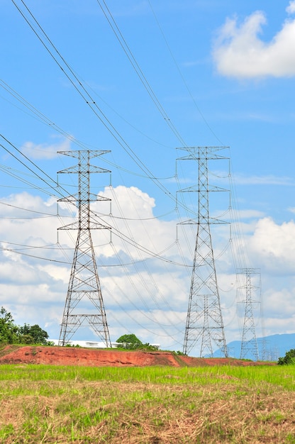 Linhas de alta tensão e torres de energia em um dia ensolarado com nuvens no céu azul