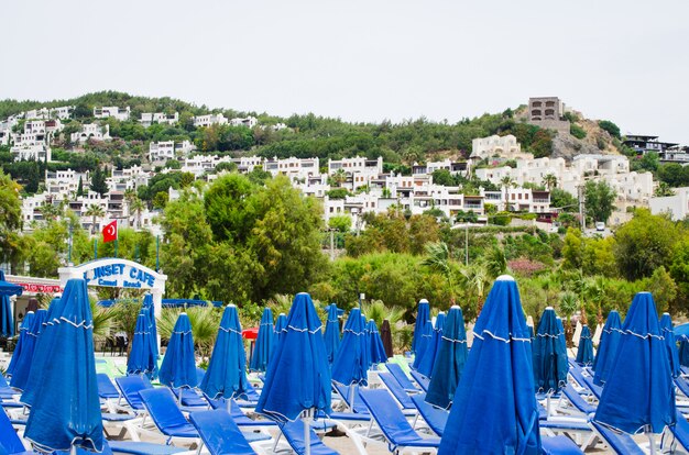 Linhas de espreguiçadeiras e guarda-sóis azuis vazios na praia. camel beach na turquia.