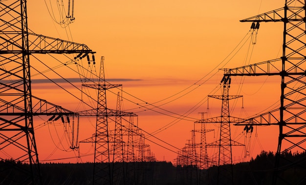 Linhas de forno elétrico com torres em um fundo por do sol