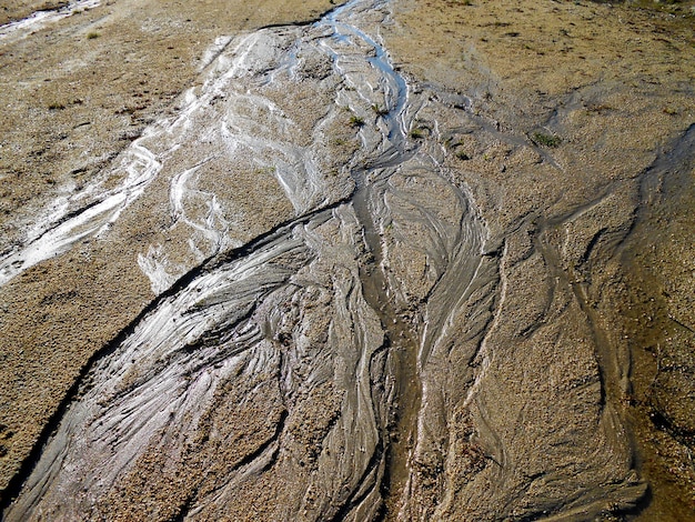 Linhas de fundo de água estrias pela areia close-up