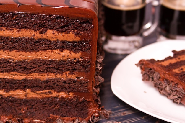 Linkshänder-Milch-Stout-Kuchen aus der Brauerei mit mehreren Schichten von Stout-infundiertem Schokoladenkuchen, gefüllt mit Stout-Schokoladenmousse und überzogen mit Milchschokolade-Ganache.