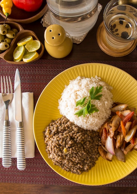 Linsen sautiertes Hähnchenreis peruanisches traditionelles Essen Mise en Place Holztisch