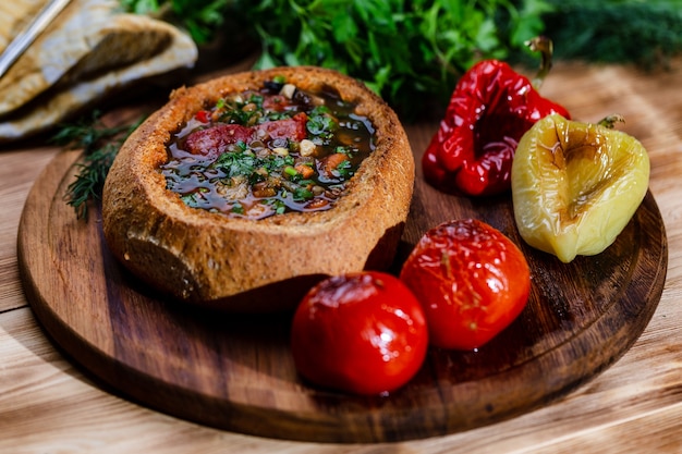 Linsensuppe mit geräucherten Schweinerippchen in einem Teller Brot