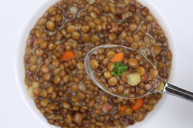 Foto linsensuppeneintopf mit linsen auf löffel von oben essen