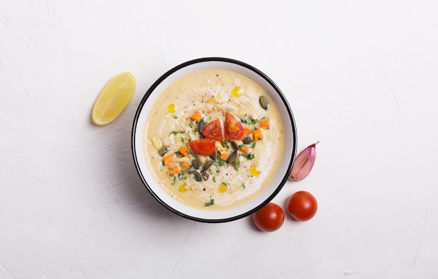 Linsensuppenpüree mit Tomaten, Gurken und Nüssen in einer Schüssel