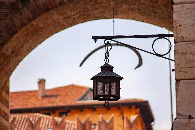 Linterna antigua en edificios medievales en la calle de Verona en Italia