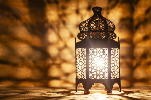Linterna árabe ornamental con vela encendida que brilla intensamente