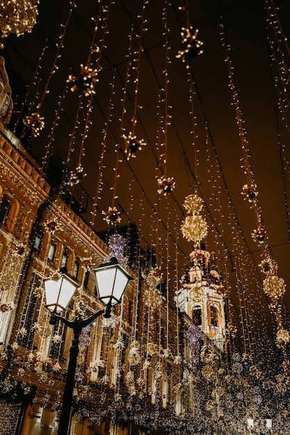 Linterna ardiente y luces doradas de la ciudad nocturna en adornos navideños festivos