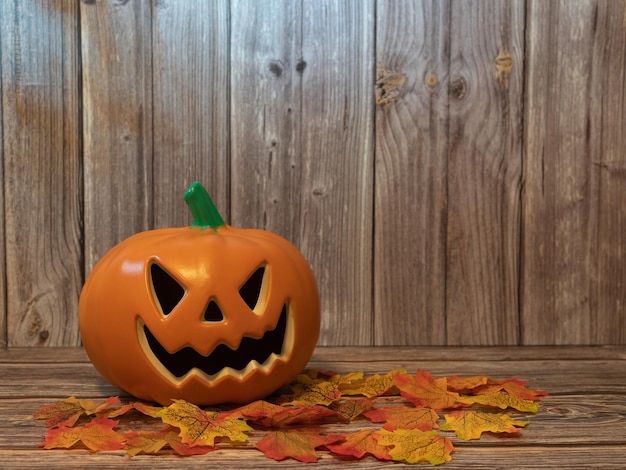 Linterna de cabeza de calabaza de Halloween con velas y una calabaza sobre fondo de madera