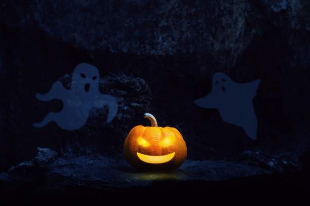 Foto linterna de calabaza y fantasma en un cementerio en la noche