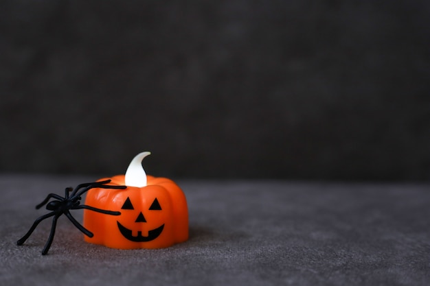 Linterna de calabaza naranja con araña negra sobre fondo marrón. Lugar para el texto. Concepto de halloween