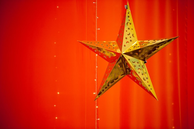 La linterna de las estrellas colgando de la pared roja