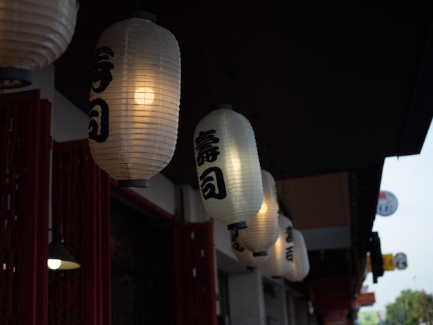 Linterna japonesa colgada frente al restaurante japonés El texto japonés en la linterna es Sushi.