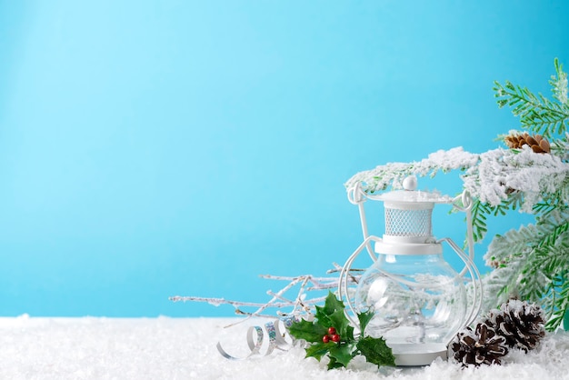 Linterna de Navidad en la nieve con rama de abeto y decoración de invierno en azul. Concepto de vacaciones de Navidad.