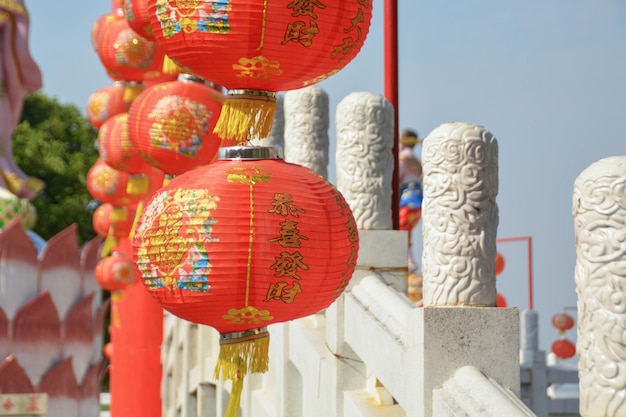 La linterna roja china ha escrito una decoración de patrones afortunados y chinos colgando del puente blanco