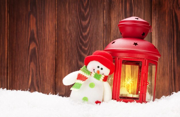 Linterna de velas navideñas y juguete de muñeco de nieve