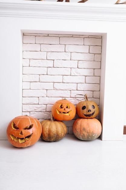 Linternas de calabazas de Halloween talladas junto a la chimenea en casa