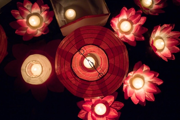 Linternas de papel flotantes en el agua por la noche.