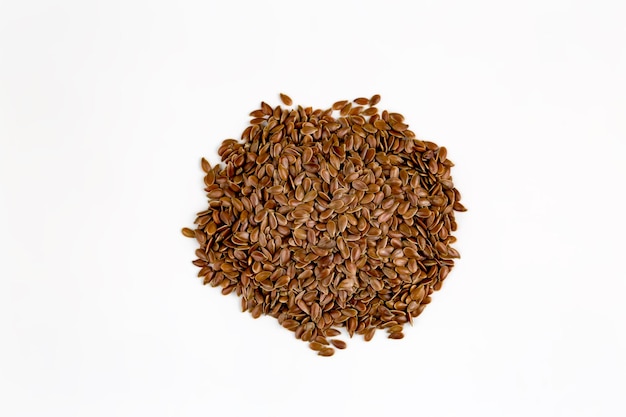 Linum usitatissimum é o nome científico da semente de linho marrom. Também conhecido como linhaça, linhaça e linho comum. Pilha de grãos, fundo branco isolado.