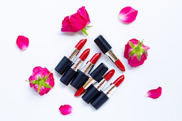 Lippenstifte mit rosafarbener Blume auf Weiß. Schönes Make-up