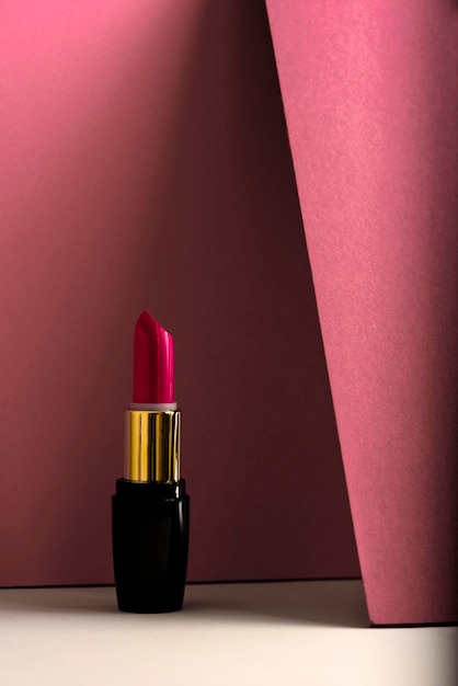 Lipstick rosa en un fondo turquesa minimalista moderno concepto de productos de maquillaje y cosméticos