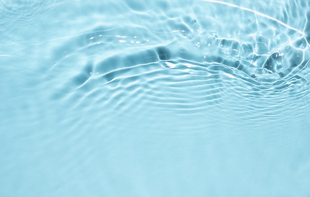 Foto líquido azul com textura de superfície de água clara com salpicos de bolhas ondas de água na luz do sol