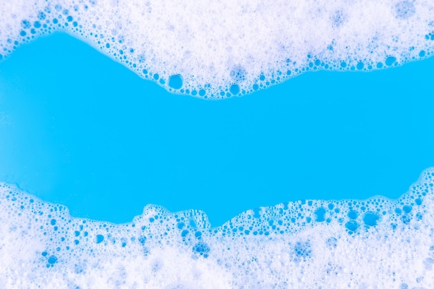 Líquido espumante em pano de fundo azul Fundo de espuma de cosméticos Amostra de produto cosmético de xampu de mousse