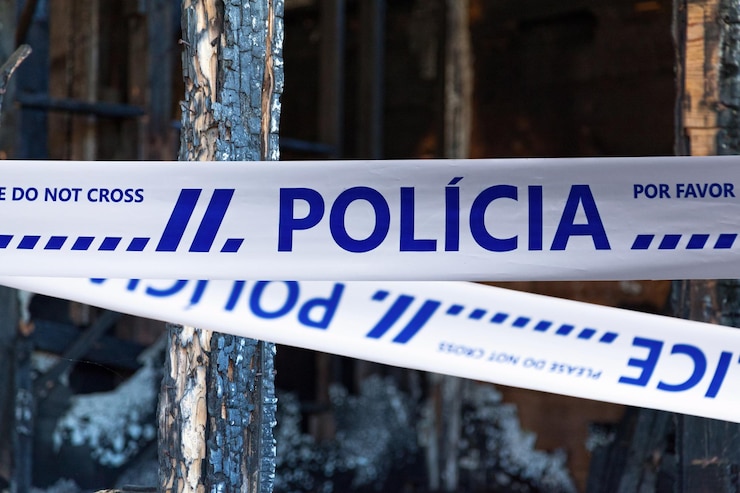 Foto lisboa, portugal - 23 de junho de 2017: casa queimada até o chão por um pirômano com uma fita policial com escrito em português "polícia".