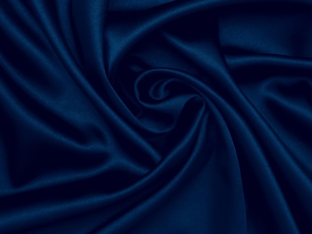 Foto liso elegante seda azul escuro pode usar como fundo design de decoração foco suave luxo e conceito sexy abstrato azul arrugado brilhante satin fabtic pano de fundo escuro com curvas moda de luxo
