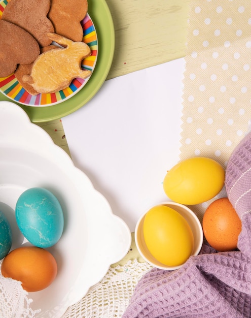 Lista blanca vacía con huevos de colores de Pascua y galletas caseras navideñas Plantilla de banner de Pascua