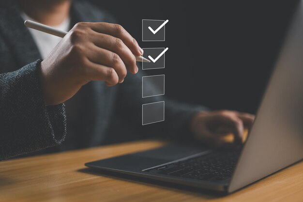 Lista de comprobación del rendimiento del negocio Empresario que utiliza una computadora portátil haciendo una lista de comprobación en línea llenando una encuesta