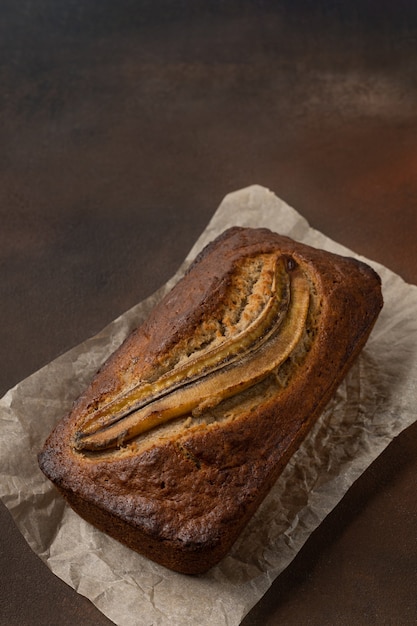 Listo pan de plátano fresco en forma rectangular sobre fondo oscuro